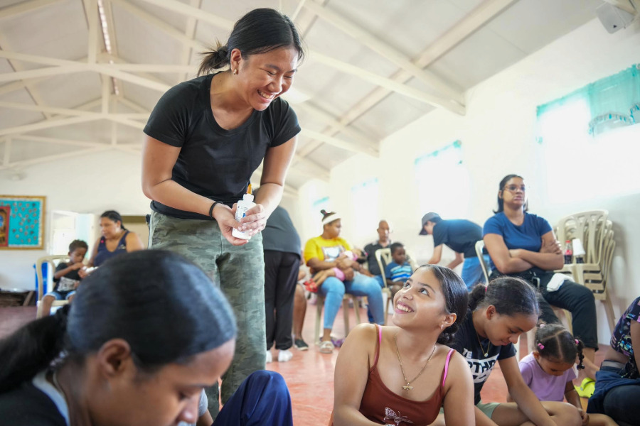 A mission team member helping a child with a craft